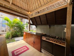 an outdoor kitchen with a stove and a counter top at Tanhana Villa Canggu in Canggu