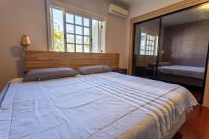 a bedroom with a large bed and a large window at Casa confortável e aconchegante in Bento Gonçalves