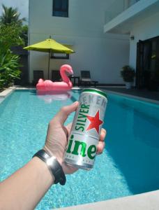 a person holding a can of sprite in front of a pool at Hoi An Lotus Aroma Villa in Hoi An