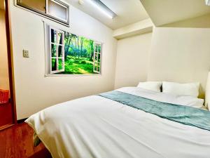 um quarto com uma cama branca e uma janela em Linkit Stay 東新宿 em Tóquio