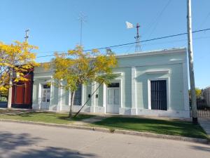 un vieux bâtiment blanc au coin d'une rue dans l'établissement La Casa del Molino, à Ramallo