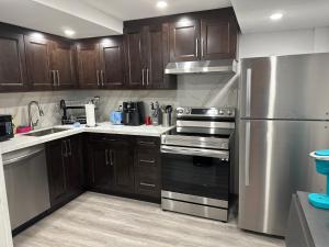 a kitchen with wooden cabinets and a stainless steel refrigerator at Tranquil Haven Retreat in Oakville