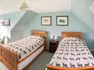 a bedroom with a bed and two pictures on the wall at Cochrane House in Kirkcudbright