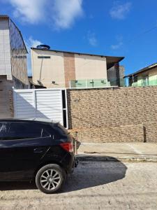 un coche negro estacionado frente a una casa en Linda Casa Itamaracá en Jaguaribe