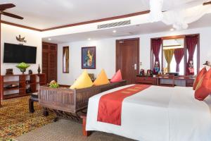 a hotel room with a bed and a television at Montra Nivesha residence and Art in Siem Reap