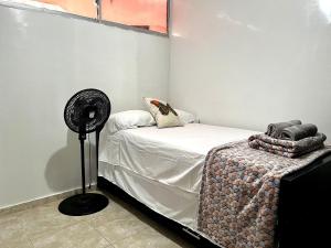 a small bedroom with a bed with a fan at Serenity Cerca CC Los Mayales in Valledupar