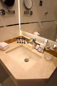 a bathroom counter with a sink and a mirror at Oriens Hotel in Taif