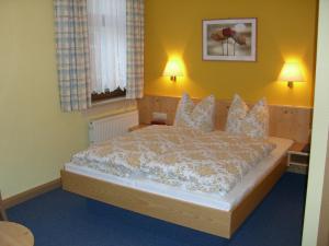 a bedroom with a large bed with two lamps at Hotel Stadt Suhl in Zella-Mehlis