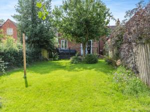 a yard with a fence and a house at Wheelwrights Cottage in Yeaveley