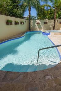 a large swimming pool with blue water at Beautiful Three Storage House Near Playa Caleta in La Romana +10 photos