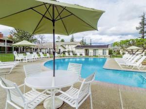 - une table blanche avec un parasol à côté de la piscine dans l'établissement Charming Napa Getaway - Minutes from Wineries, à Napa