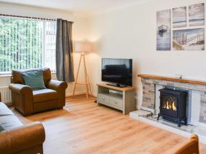 a living room with a fireplace and a television at Gwynfa in Rhyl