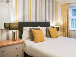 a bedroom with a large bed with yellow pillows at Askham House in York