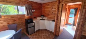 a kitchen in a log cabin with a sink and a stove at Forest Peak Motel in Hanmer Springs