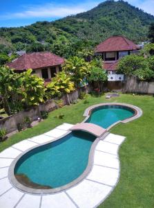 a swimming pool in the yard of a house at Dalia Budget Hotel in Senggigi