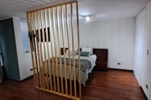 1 dormitorio con 1 cama y suelo de madera en Cómodo Dpto Home Estudio 1501, en Santiago