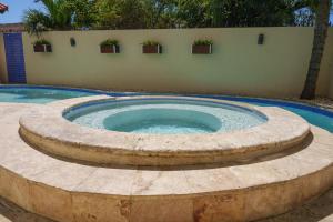 a circular pool with a fountain in a yard at Beautiful Three Storage House Near Playa Caleta in La Romana