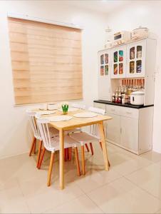 kuchnia z drewnianym stołem i białymi krzesłami w obiekcie Rodriguez, Rizal w mieście Rodriguez