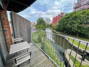 a wooden balcony with a bench and a river at Cityfront Modern Apt Near City Centre/Etihad, Free Parking in Manchester