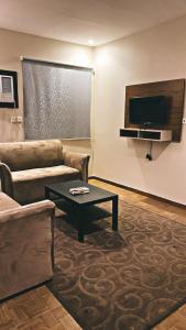uma sala de estar com um sofá e uma mesa de centro em فندق اضواء المدينة em Sīdī Ḩamzah