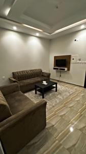 ein Wohnzimmer mit einem Sofa und einem Tisch in der Unterkunft فندق اضواء المدينة in Sīdī Ḩamzah