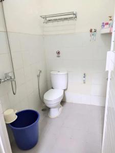a bathroom with a toilet and a blue bucket at Latasari 33A Homestay in Tuban
