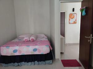 Latasari 33A Homestay في Tuban: غرفة نوم مع سرير وردي مع وسائد عليها