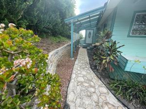 una casa con una pasarela de piedra junto a un edificio en Ha'le Kiana, en Kula