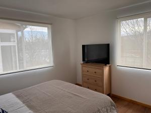 a bedroom with a bed and a flat screen tv at Casas Altos del Simpson in Coihaique