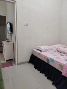 a bedroom with a bed and a flat screen tv at Latasari 33A Homestay in Tuban
