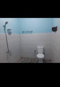 y baño con aseo blanco y ducha. en RIUNG LALONG TERONG Guest House, en Riung
