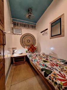 ein Schlafzimmer mit einem Bett und einem Tisch darin in der Unterkunft Balai Vivencio Hostel in Puerto Princesa