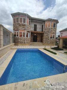 a house with a swimming pool in front of a house at Golden Villa in Daşca