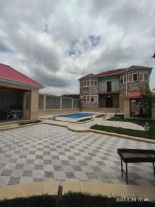 a house with a checkered courtyard with a pool at Golden Villa in Daşca