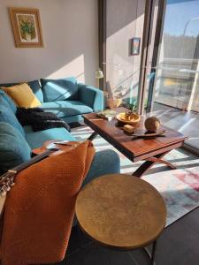 a living room with a couch and a table at GREEN ROSE ~ Peaceful • Green • Haven in Canberra