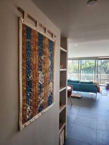 a quilt hanging on a wall in a living room at GREEN ROSE ~ Peaceful • Green • Haven in Canberra