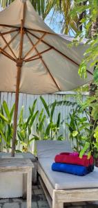 a bed with an umbrella next to a table at Gili Moonlight Retreat in Gili Air