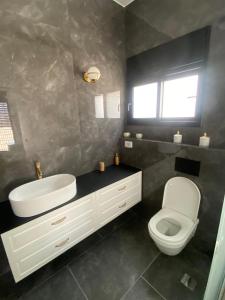 a bathroom with a white sink and a toilet at best apartment in buhcman (shivtie Israel 26) in Modi'in-Maccabim-Re'ut