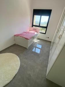 Habitación pequeña con cama y ventana en best apartment in buhcman (shivtie Israel 26), en Modi'ín