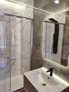 baño blanco con ducha y lavamanos en Residencial Europa, en Salamanca