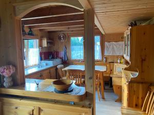 eine Küche und ein Esszimmer mit einem Tisch in einer Hütte in der Unterkunft CHALET JOEN ski & bike Andalo in Andalo