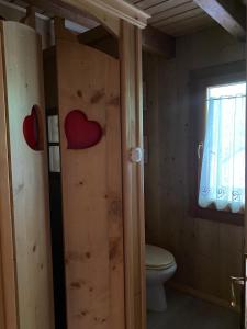 bagno con servizi igienici e 2 cuori sulla porta di CHALET JOEN ski & bike Andalo ad Andalo