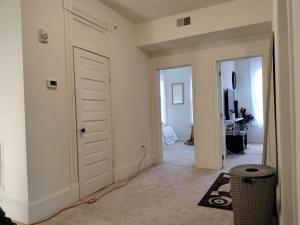 a hallway with a white door and a room at Gorgeous ,stylish and Beautiful Luxury Apartment with stuning Downtown View.Featuring American and French style in Frederick