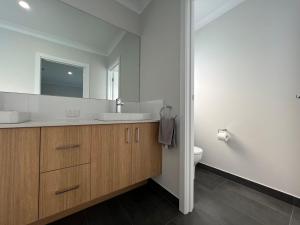 a bathroom with a sink and a toilet and a mirror at Relaxation On Rodondo in Inverloch +15 photos