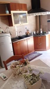 馬恰尼塞的住宿－Mini appartamento a Marcianise，厨房配有水槽和鲜花桌