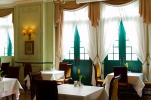 a dining room with tables and chairs and windows at Hotel Monterey Nagasaki in Nagasaki