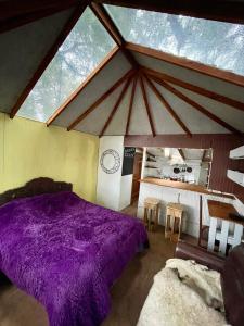 ein Schlafzimmer mit einem lila Bett in einem Zimmer in der Unterkunft Refugio El Cauque in Puerto Williams