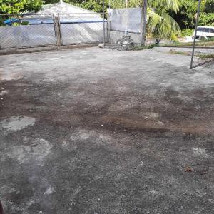 un estacionamiento sucio con una valla en el fondo en Haira Traveller's Home, en Iligan