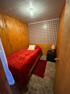 a small bedroom with a red bed in a room at Hospedaje Pudahuel in Santiago