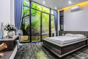 a bedroom with a bed and a large window at F.Home Modern & Art 3BR Near My Khe Beach in Danang